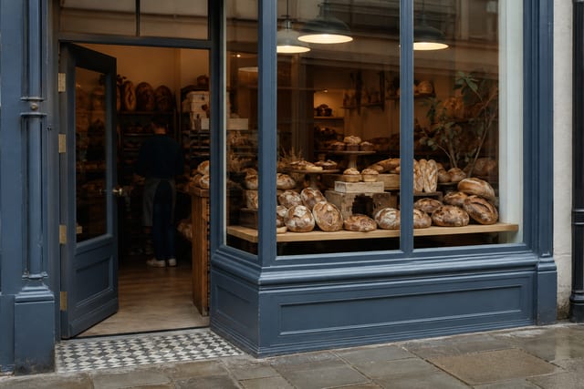 A UK bakery shopfront with bread in the window, photographed from the pavement.